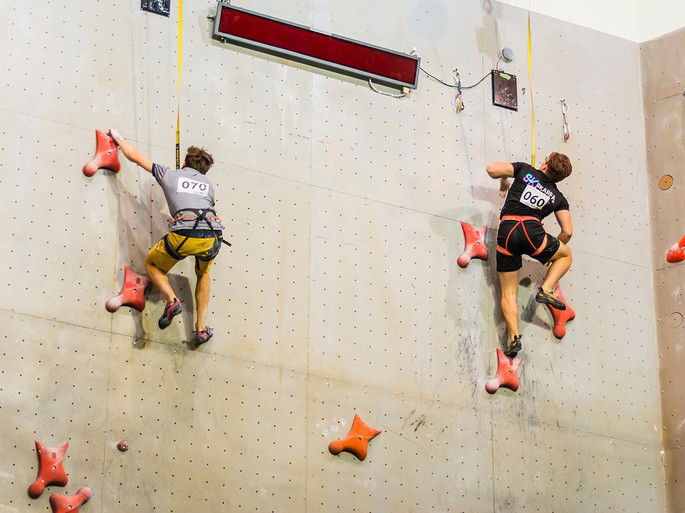Competição entre dois juniores em parede de escalada de velocidade padronizada
