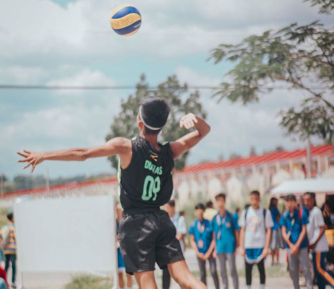 Jogador de voleibol com bola na quadra de vôlei