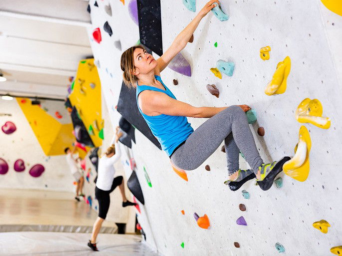 Mulher em escalada artificial