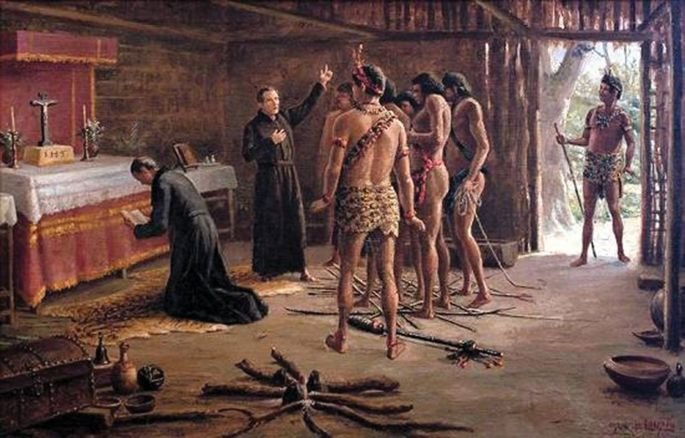 A tela Na cabana de Pindobuçu (1920), de Benedito Calixto, retrata missionários jesuítas catequizando indígenas