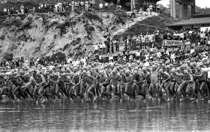 pessoas entrando na água em uma das primeiras provas de triatlo