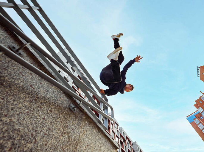 jovem praticando parkour em corrimão