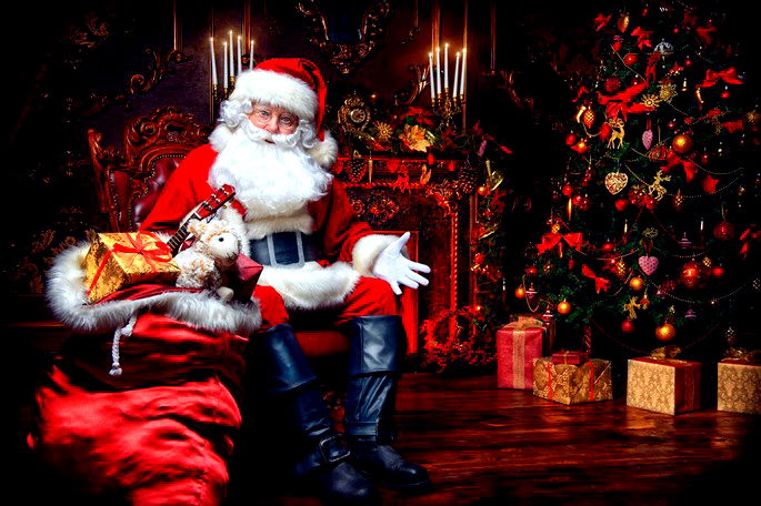 Papai Noel sentado junto à árvore de Natal e à lareira