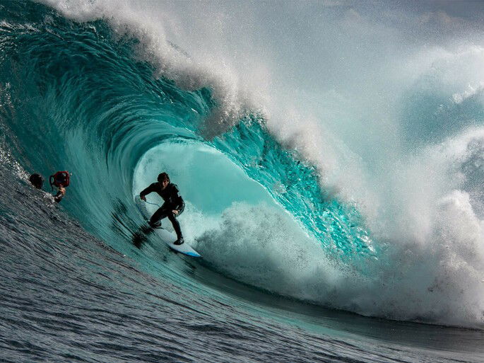 Surfista fazendo a manobra de tubo, onde ele fica no meio da onda que esta quebrando
