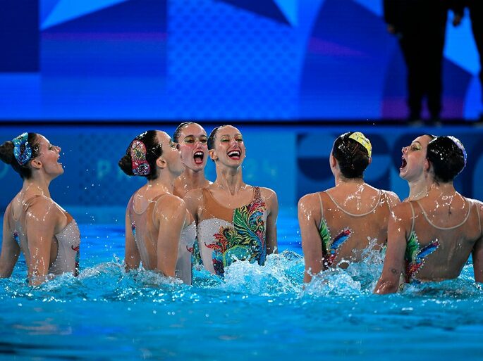 equipe de nado artístico reunida dentro da piscina