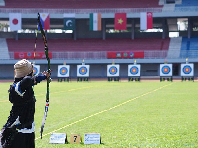 arqueira se preparando para atirar a flecha em direção ao alvo no tiro com arco