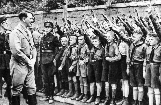 Hitler sendo saudado por crianças e jovens unifomizados