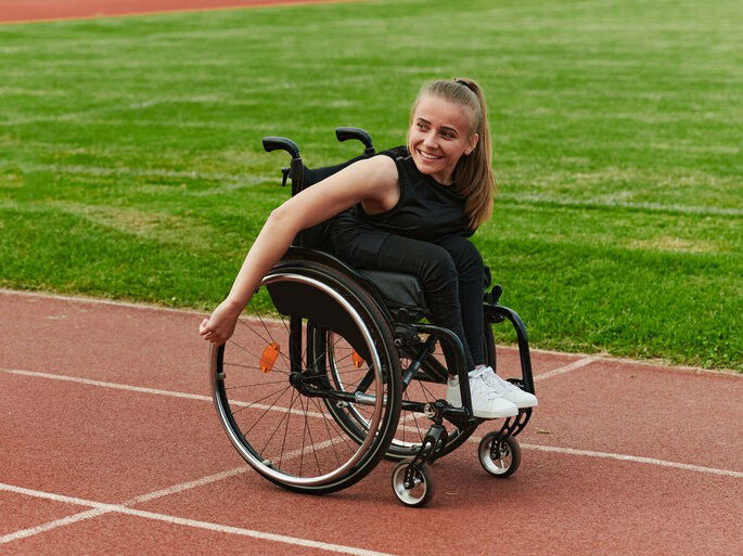 Mulher cadeirante em uma pista de atletismo