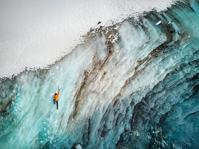 Escalada de gelo na grande parede congelada do glaciar de íon de gelo Bogdanovich